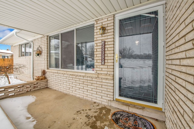 property entrance featuring brick siding and a patio area