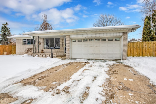 ranch-style home featuring an attached garage, fence, and brick siding