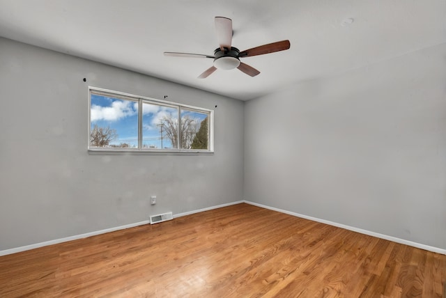 unfurnished room with visible vents, light wood finished floors, and baseboards