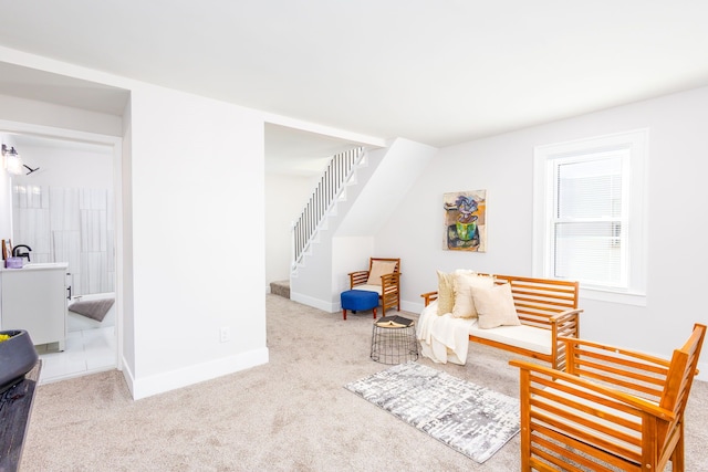 sitting room featuring carpet floors, stairs, and baseboards