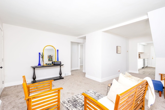 living room featuring baseboards and light colored carpet