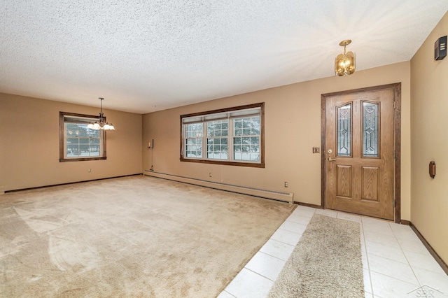 tiled entrance foyer featuring a baseboard heating unit, baseboards, carpet, a notable chandelier, and a textured ceiling