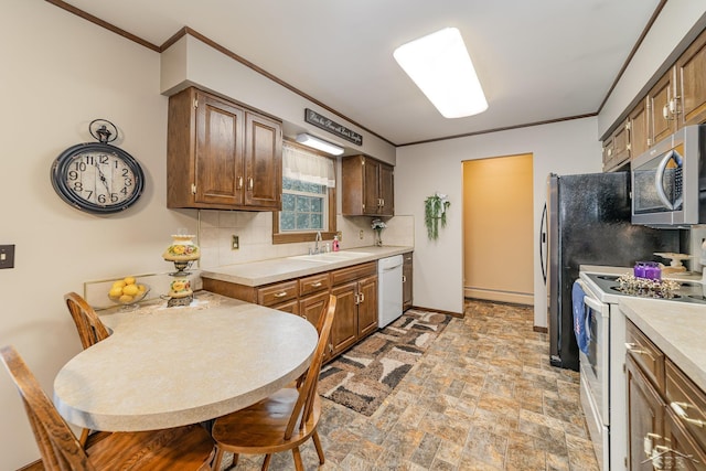 kitchen with tasteful backsplash, crown molding, light countertops, white appliances, and a sink