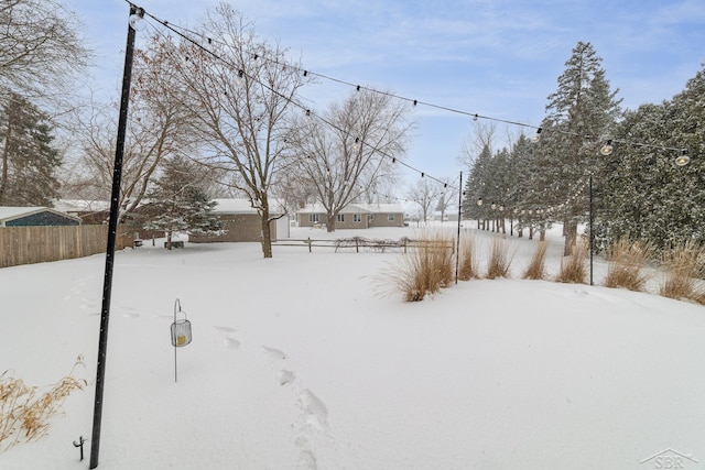 snowy yard featuring fence