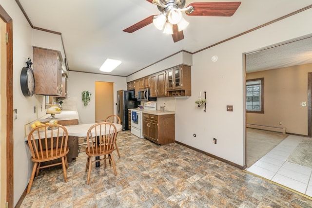 kitchen with appliances with stainless steel finishes, light countertops, a baseboard heating unit, and baseboards