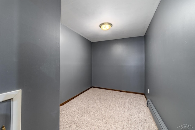 spare room featuring carpet flooring, baseboards, and a baseboard radiator