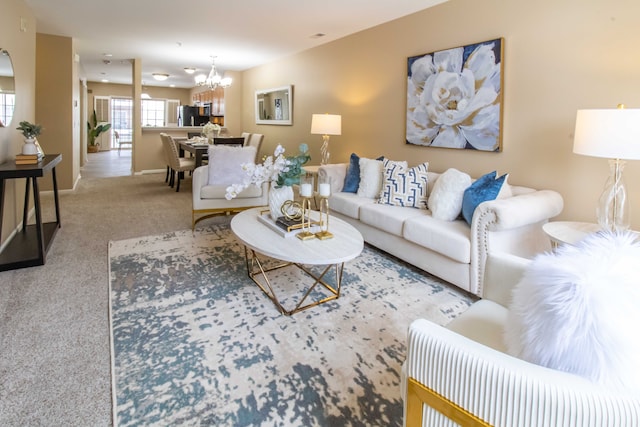 carpeted living room featuring an inviting chandelier