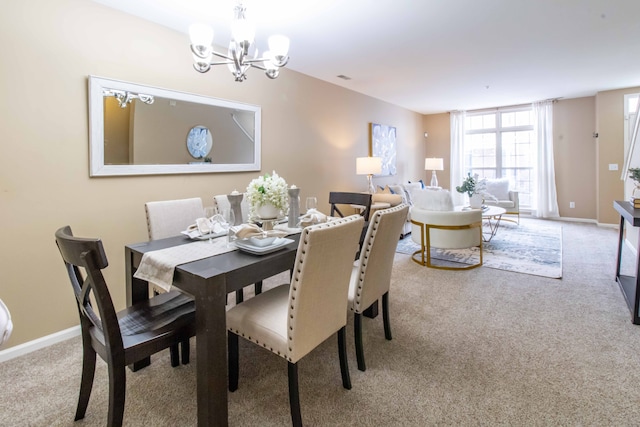 carpeted dining room featuring a notable chandelier