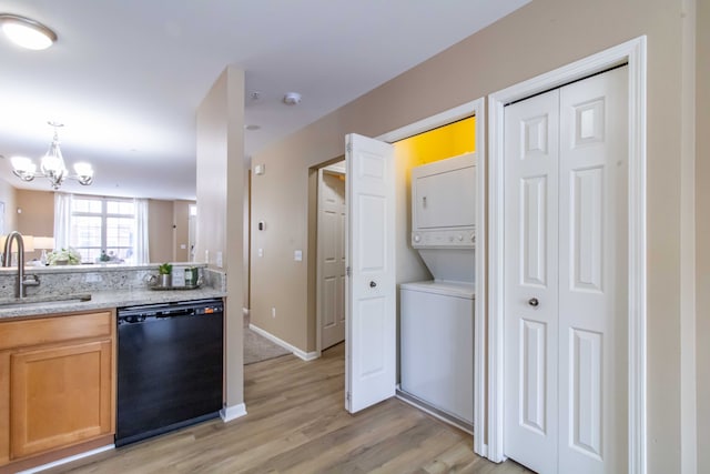 kitchen featuring light hardwood / wood-style flooring, dishwasher, stacked washer and clothes dryer, pendant lighting, and sink