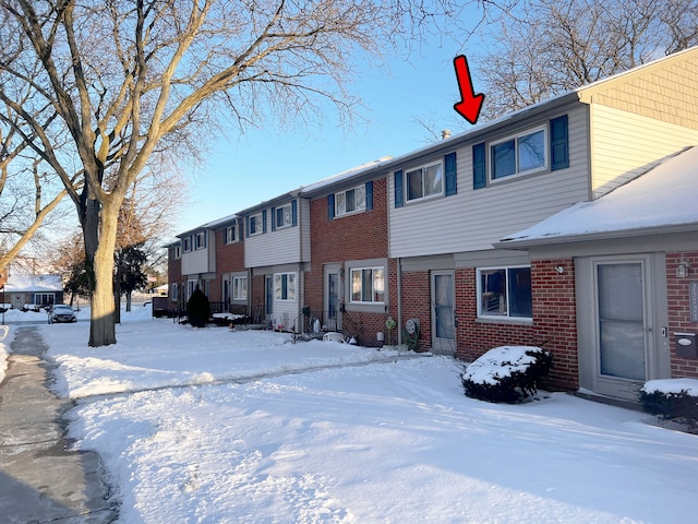 view of snow covered back of property