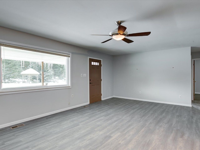 empty room with ceiling fan and hardwood / wood-style floors