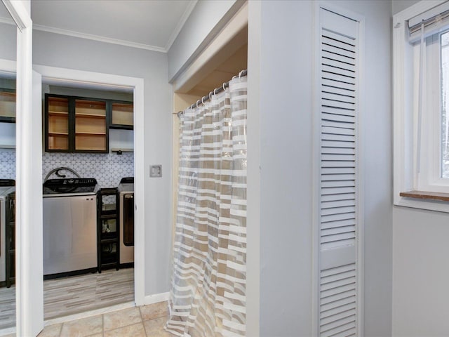 kitchen featuring washing machine and dryer, ornamental molding, and decorative backsplash