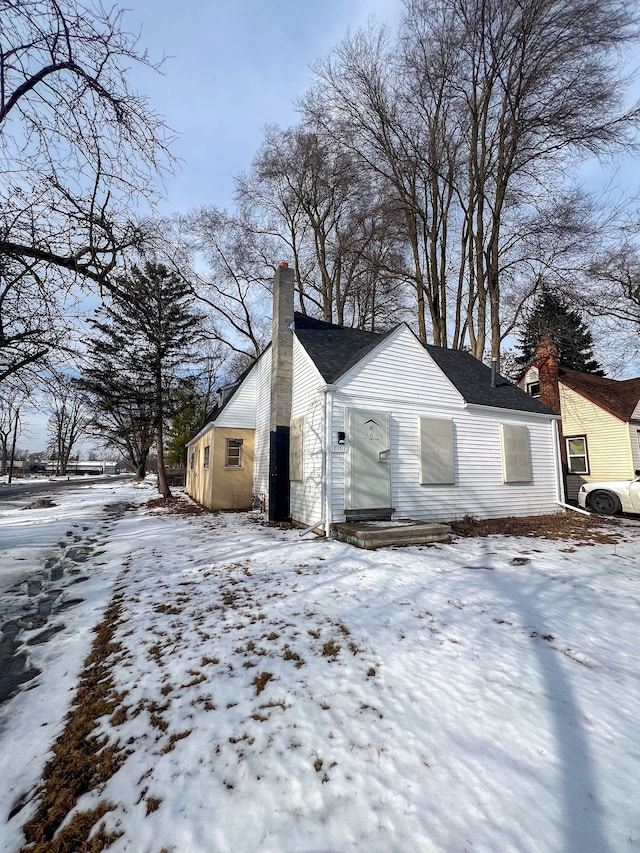 view of snow covered exterior featuring a chimney