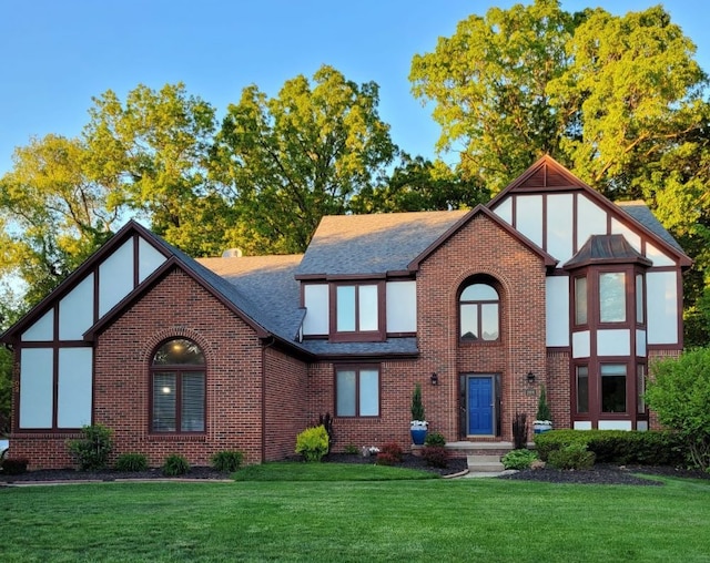 tudor-style house featuring a front yard