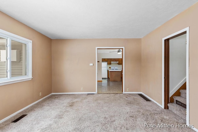 carpeted spare room with ceiling fan