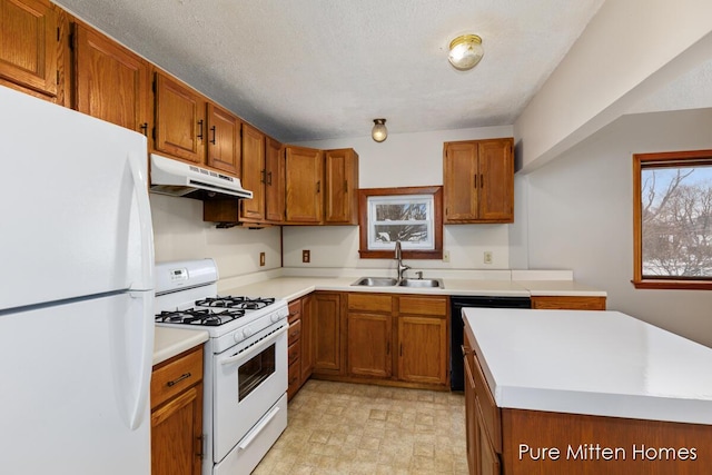 kitchen featuring white appliances, sink, and a textured ceiling