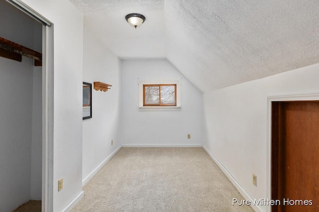 additional living space with carpet floors, a textured ceiling, and vaulted ceiling