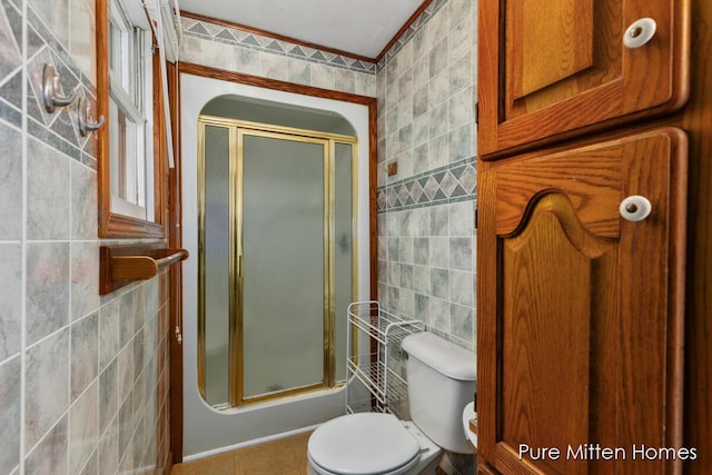 bathroom with tile walls, toilet, and walk in shower