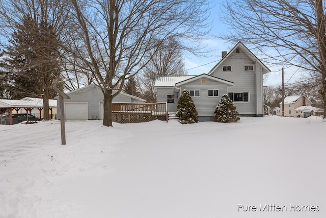 exterior space with an outbuilding, a garage, and a deck