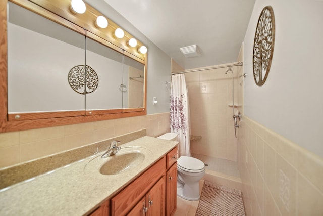 bathroom with tile walls, tile patterned flooring, vanity, walk in shower, and toilet