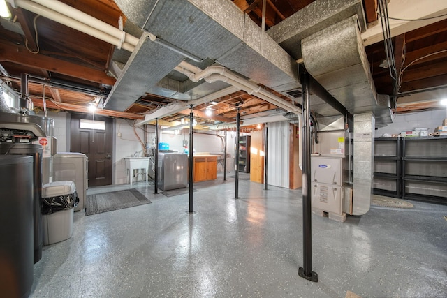 basement with sink, washing machine and dryer, and heating unit