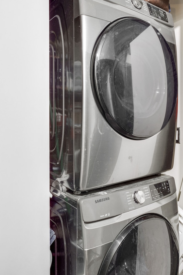 clothes washing area featuring stacked washer and dryer