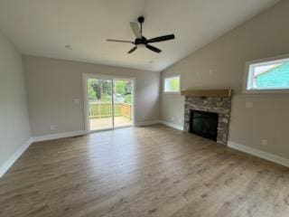 unfurnished living room with wood finished floors, ceiling fan, a fireplace, baseboards, and vaulted ceiling