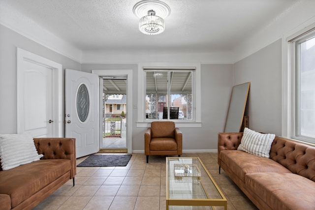 interior space with light tile patterned floors, a textured ceiling, baseboards, and a wealth of natural light