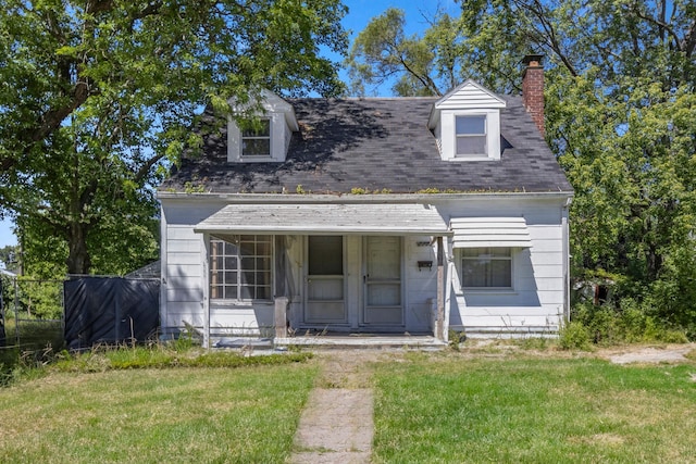 new england style home featuring covered porch and a front lawn