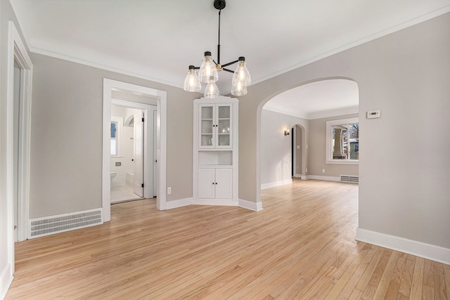 unfurnished dining area with light hardwood / wood-style floors and crown molding