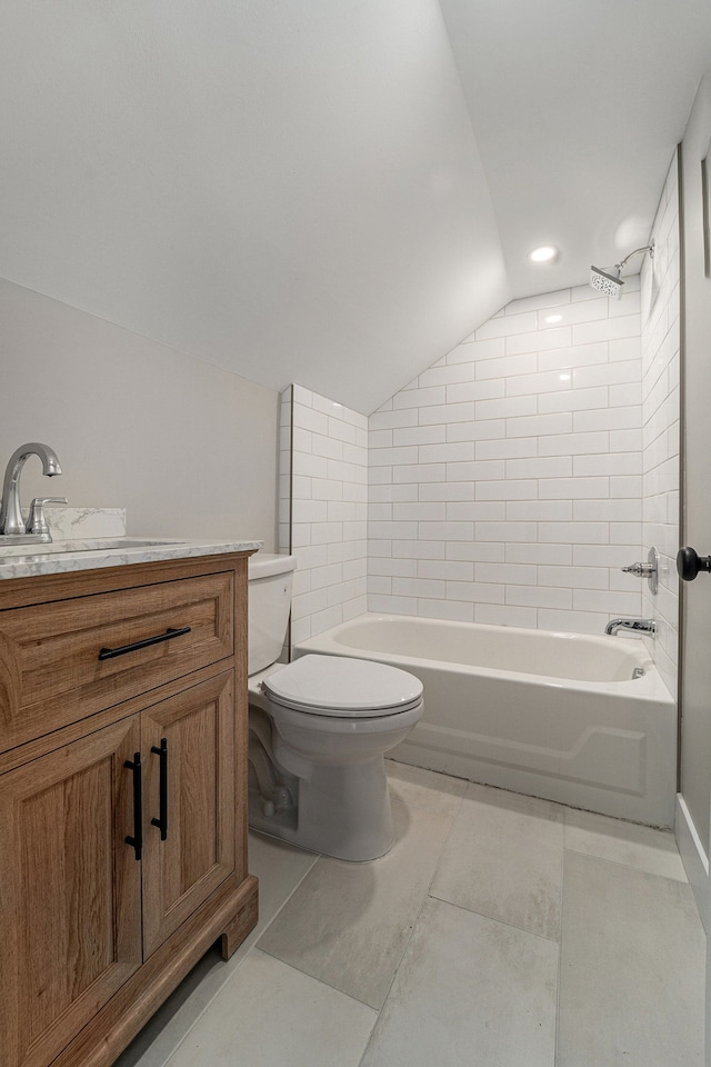 full bathroom featuring tiled shower / bath combo, vanity, vaulted ceiling, and toilet