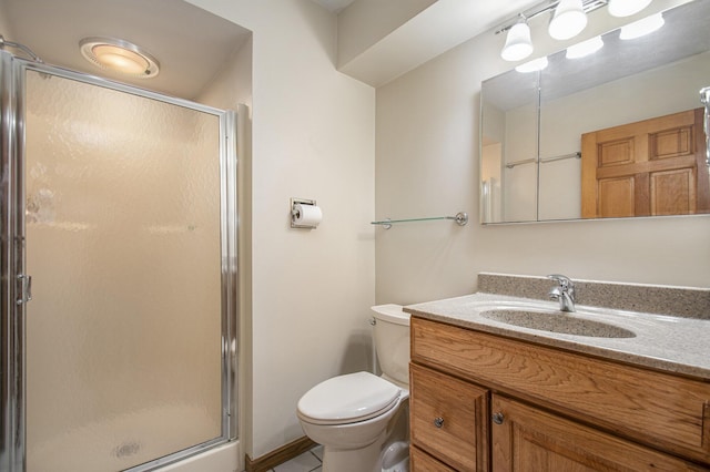 bathroom featuring vanity, toilet, and a shower with shower door