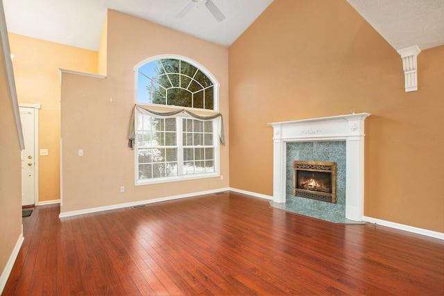 unfurnished living room featuring hardwood / wood-style floors, high vaulted ceiling, plenty of natural light, and a fireplace