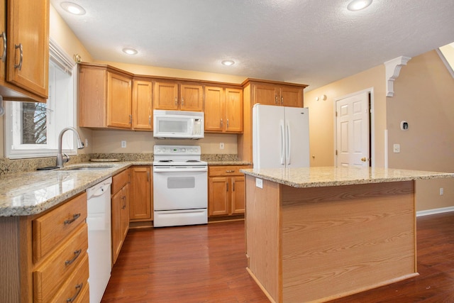 kitchen with white appliances, sink, a kitchen island, and dark hardwood / wood-style floors