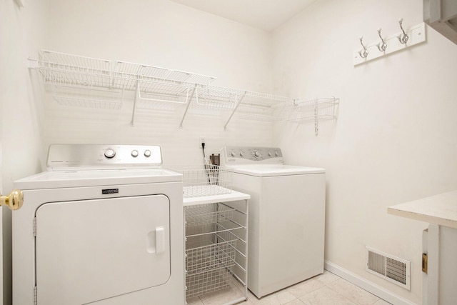 washroom featuring light tile patterned flooring and washing machine and clothes dryer