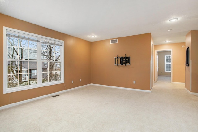 carpeted empty room featuring a wealth of natural light