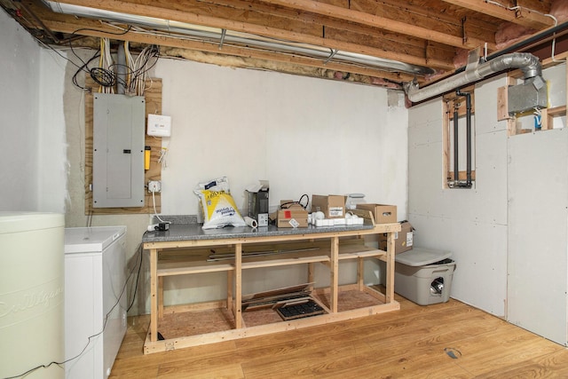 basement with hardwood / wood-style floors, electric panel, and separate washer and dryer