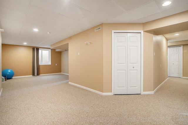 interior space featuring carpet flooring and a paneled ceiling