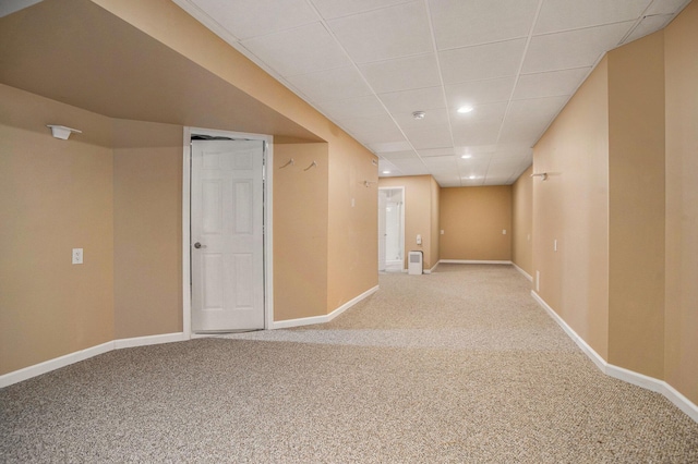 spare room with a paneled ceiling and carpet flooring