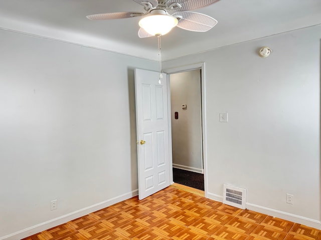 empty room featuring ceiling fan and light parquet floors