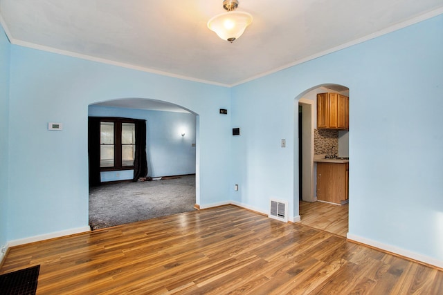 unfurnished room with light hardwood / wood-style flooring and ornamental molding