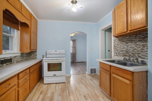 kitchen with light hardwood / wood-style flooring, backsplash, electric range, ornamental molding, and sink