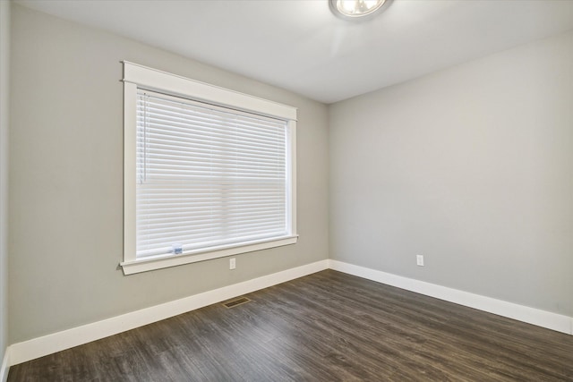 spare room with dark wood-type flooring