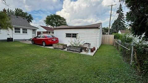 rear view of house with a yard and an outbuilding