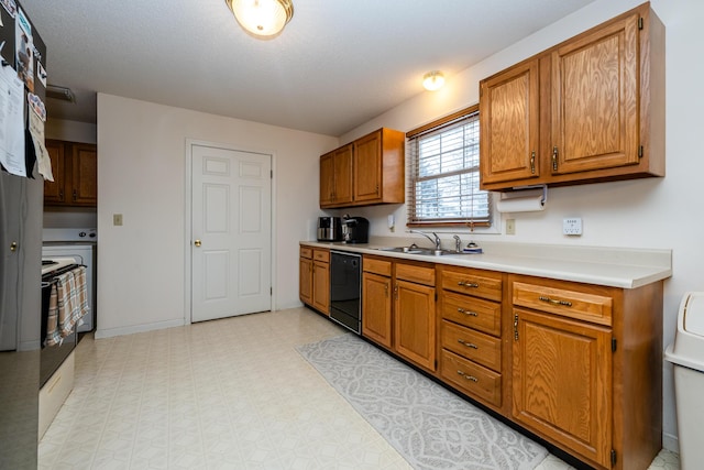 kitchen with sink, black dishwasher, and a textured ceiling