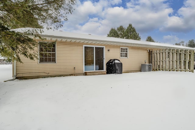 snow covered house with central AC