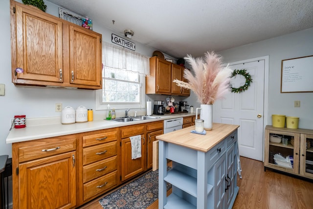 kitchen featuring sink, a textured ceiling, butcher block countertops, dark wood-type flooring, and white dishwasher