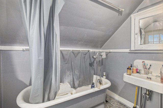 bathroom with shower / tub combo and lofted ceiling