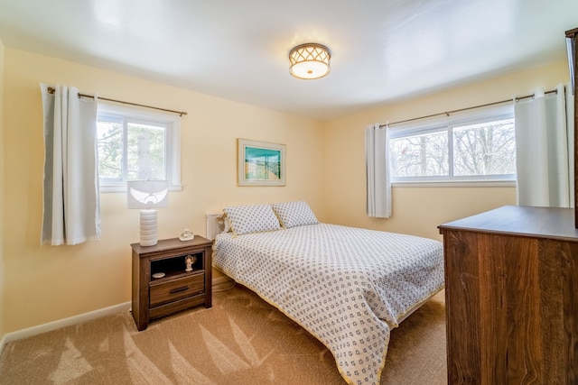 bedroom with multiple windows and light colored carpet