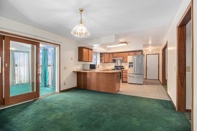 kitchen featuring brown cabinetry, a peninsula, hanging light fixtures, stainless steel appliances, and under cabinet range hood